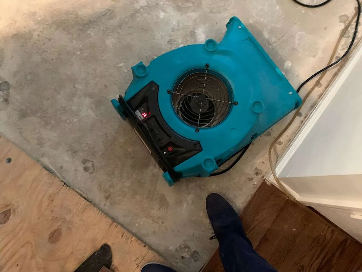 Air mover drying subfloor during Commercial Water Damage Restoration in Eagle Lake
